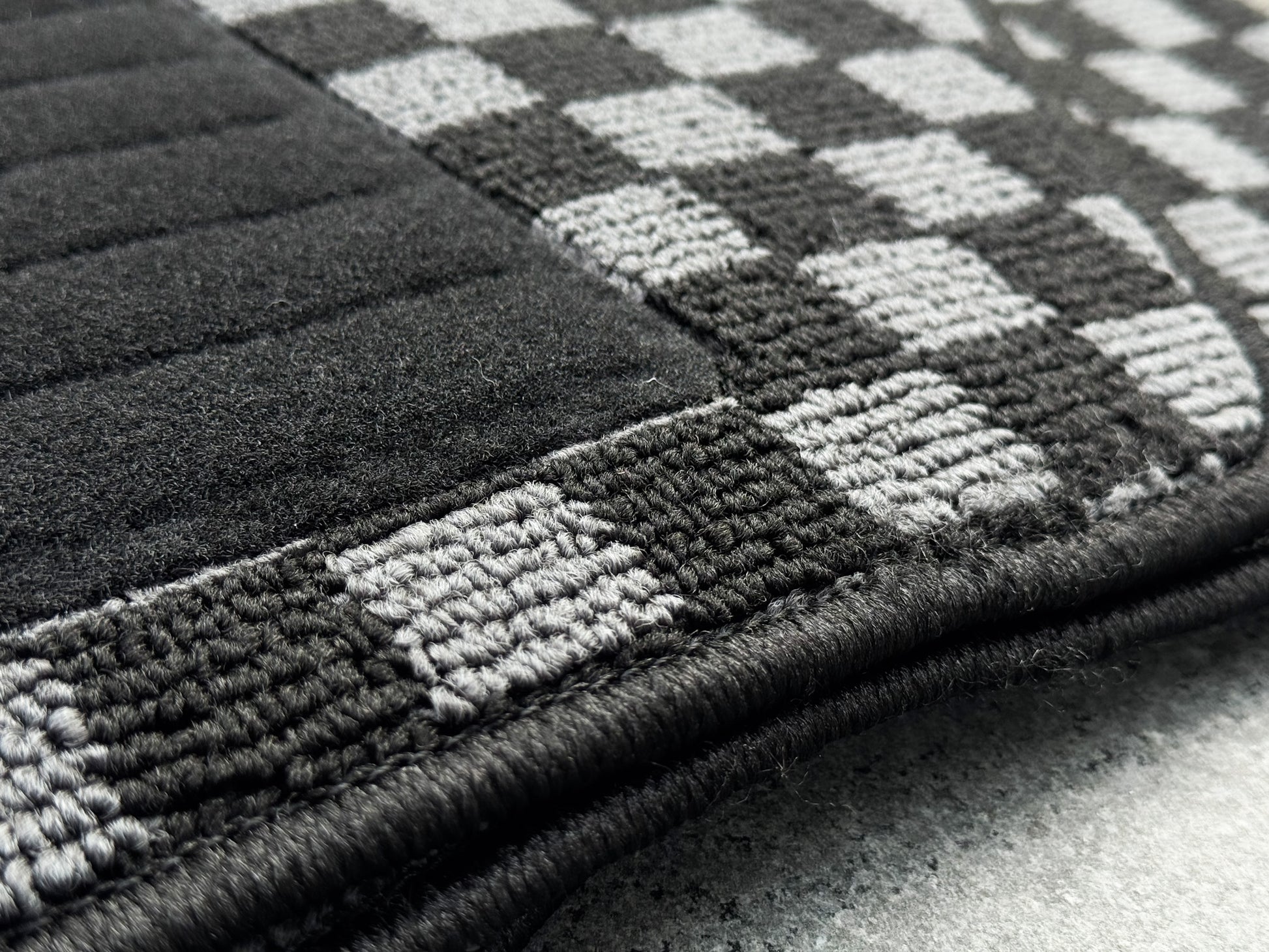 Reinforced black heel pad on Nissan Skyline R34 BNR34 checker floor mat driver side