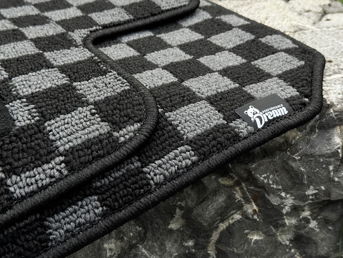 Nissan Skyline R34 GTT checker floor mats in black and grey with woven brand label