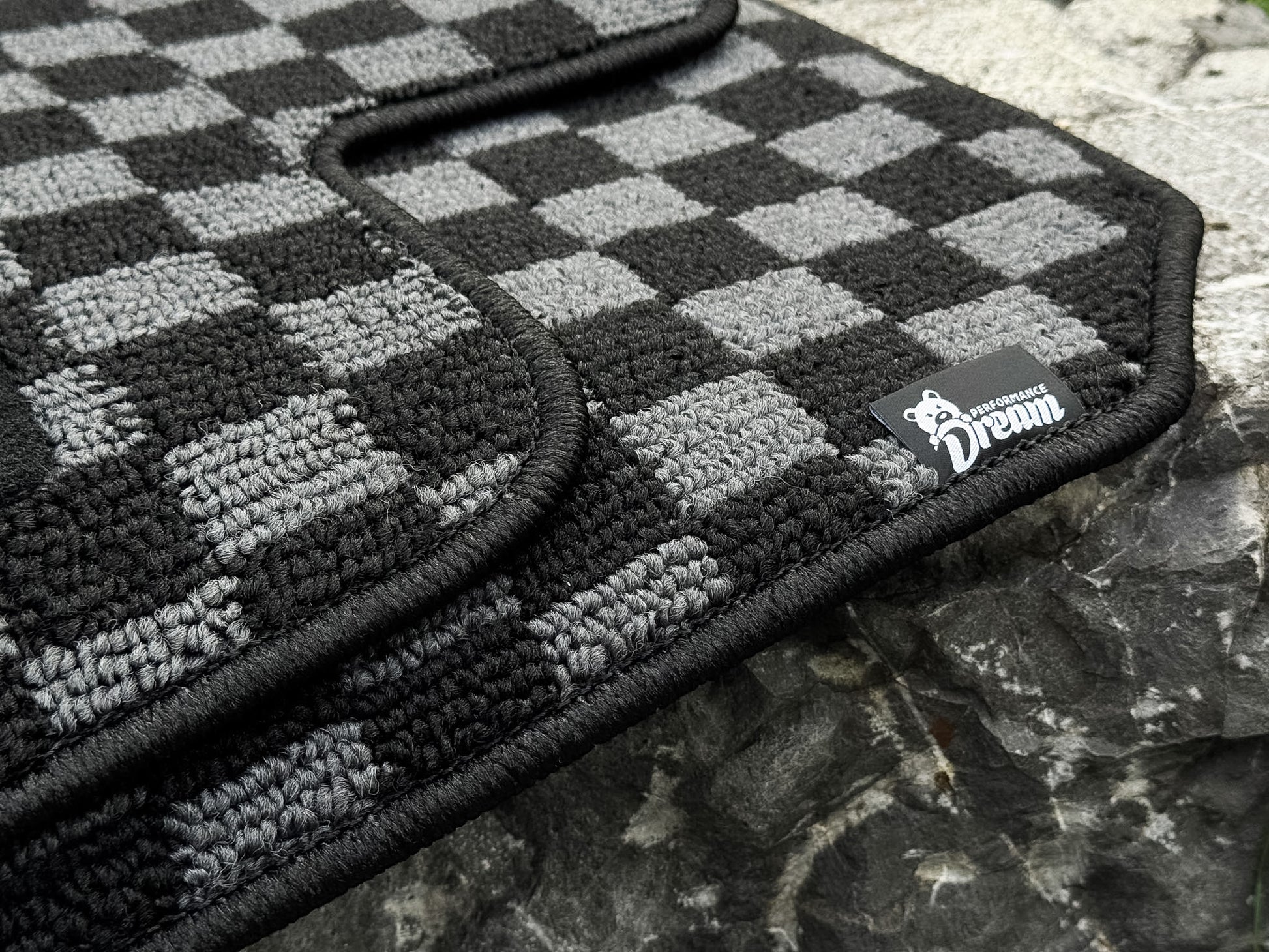 Nissan Skyline R34 GTT checker floor mats in black and grey with woven brand label