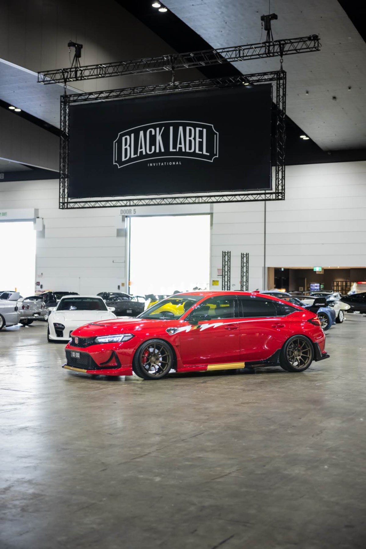Red Honda Civic Type R FL5 with Mugen style side graphic decal on display at the Black Label Invitational car show