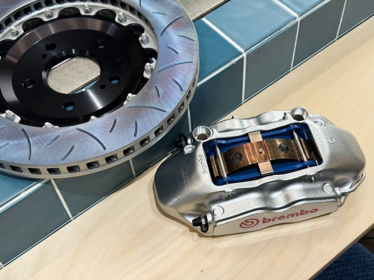 Rebuilt Brembo F50 caliper next to 330mm slotted brake disc for Honda NSX and S2000
