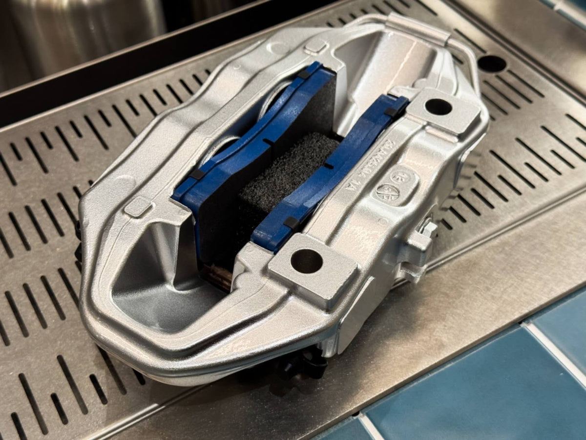 Bracket side of rebuilt Brembo F50 caliper with blue backed brake pads fitted