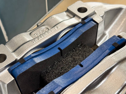 Close up of brake pads seated inside rebuilt Brembo F50 caliper