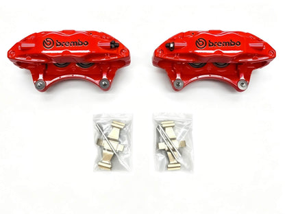 Red Brembo F50 caliper pair laid flat with anti rattle clips and retaining pins