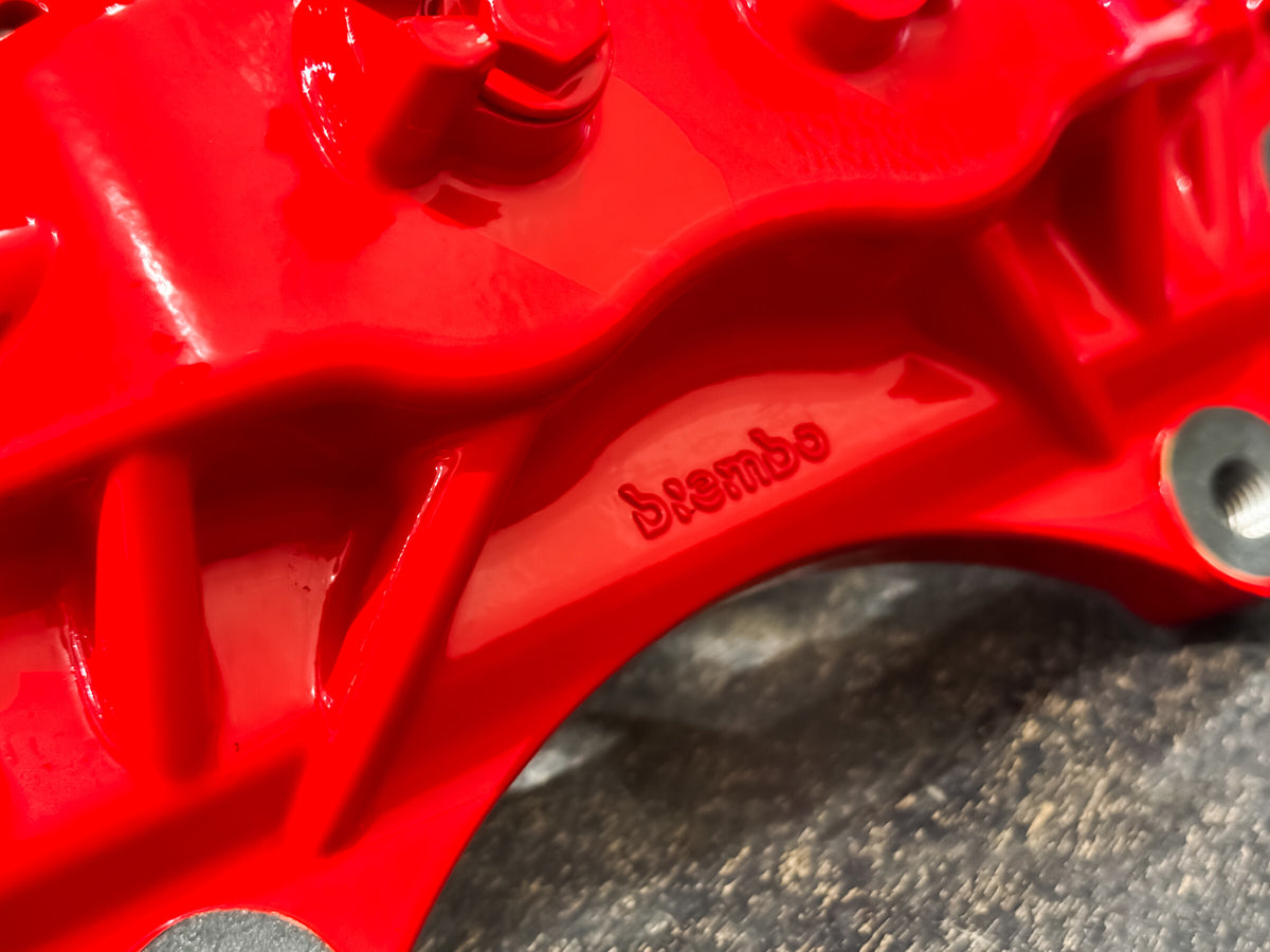 Cast Brembo lettering on the red caliper bridge