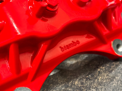 Cast Brembo lettering on the red caliper bridge