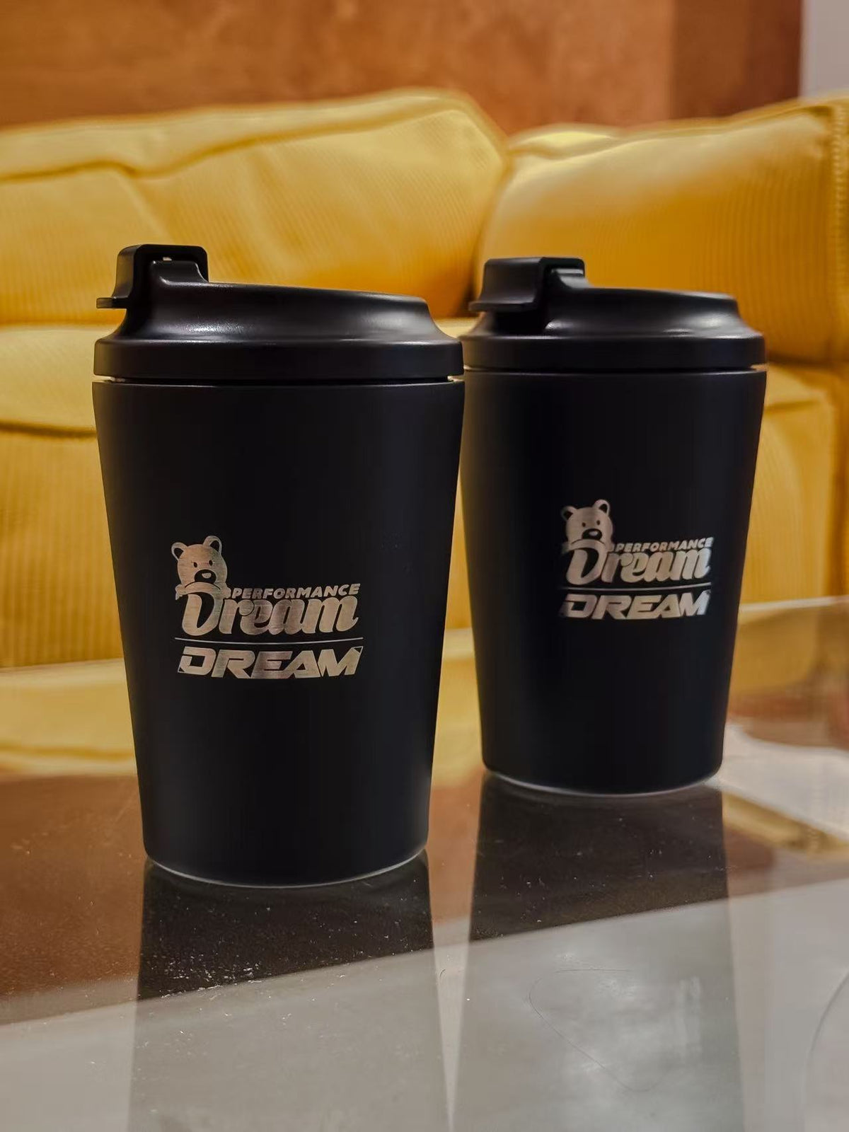 Pair of black Dream Performance x Fressko 12oz reusable coffee cups