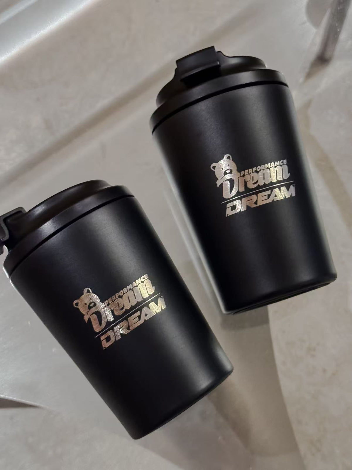 Dream Performance x Fressko coffee cups laid flat showing engraved logo