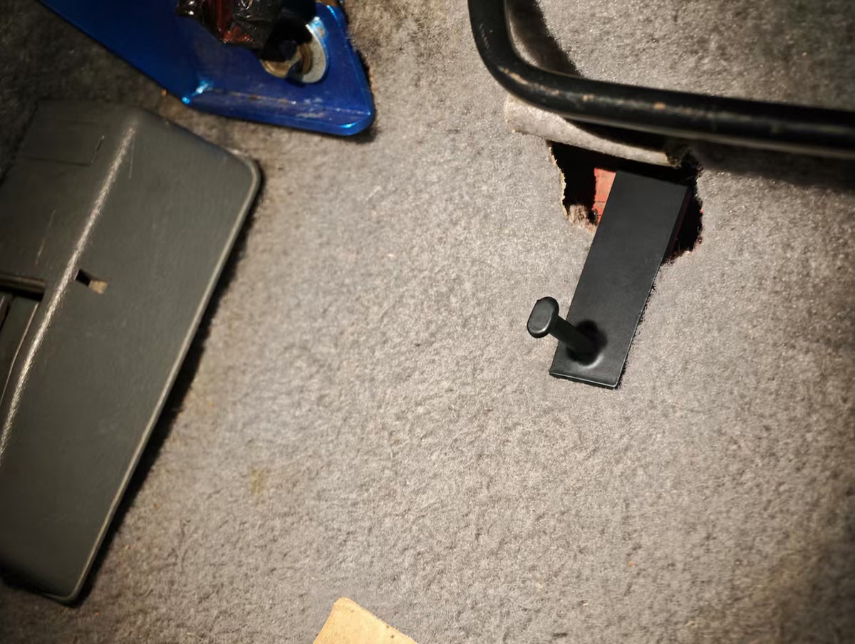 Floor mat hook installed on the floor of a Honda Civic, top view