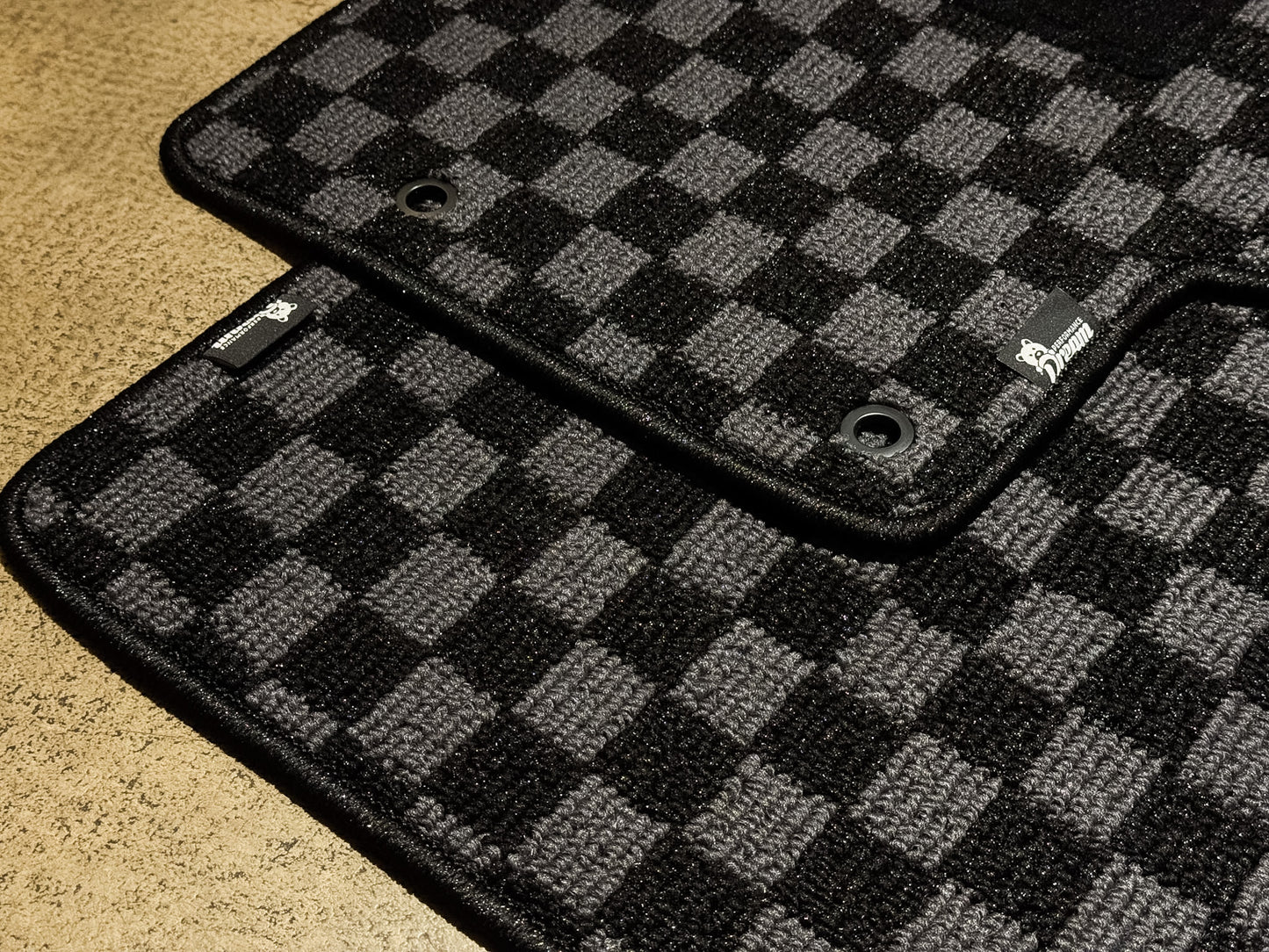 Corner detail of the grey and black checker carpet and black binding
