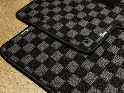 Corner detail of the grey and black checker carpet and black binding