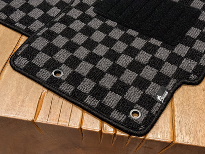 Angled view of a checker floor mat showing the shaped edge and fixing eyelet