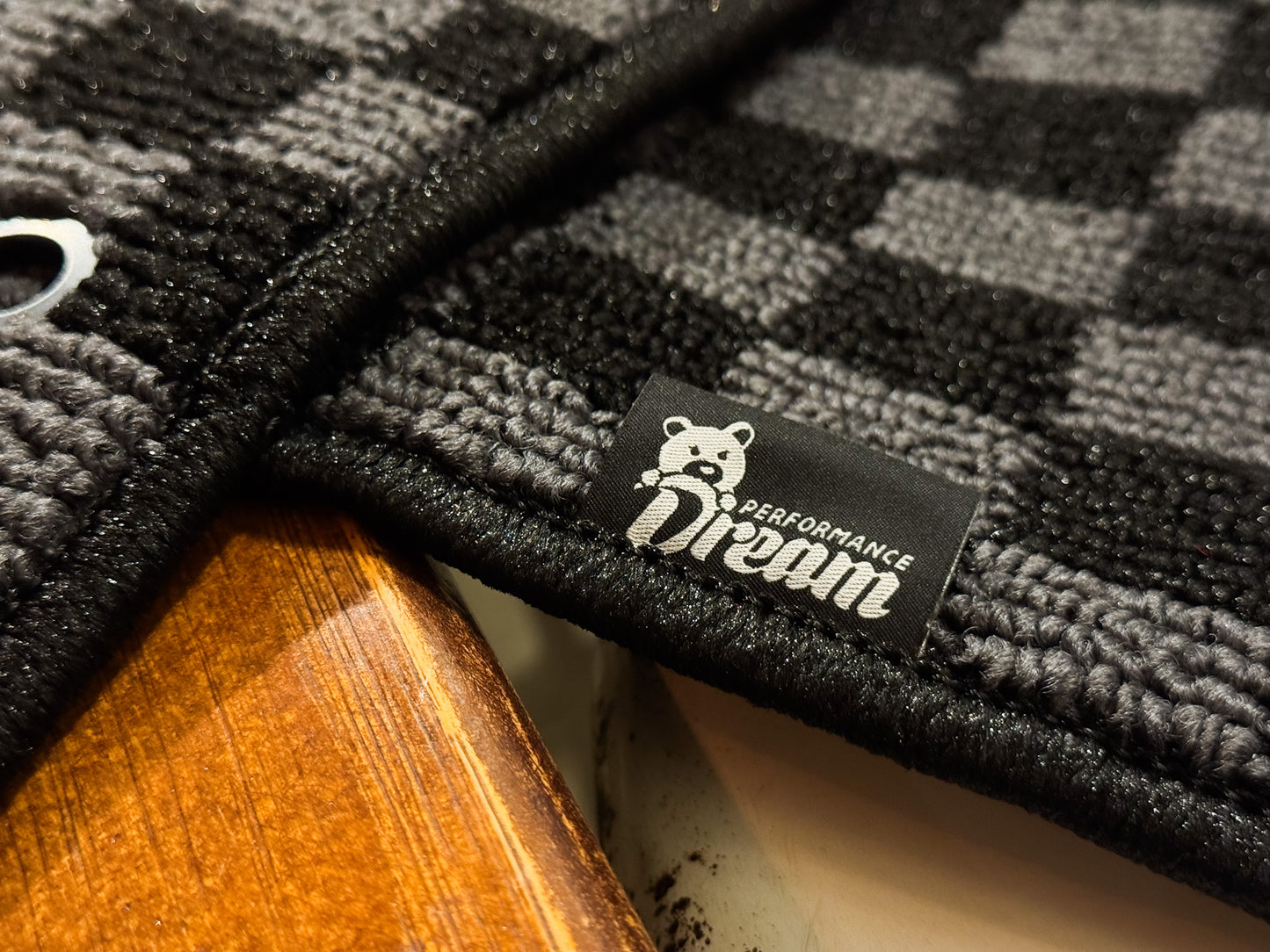 Dream Performance badge stitched onto the bound edge of a checker floor mat