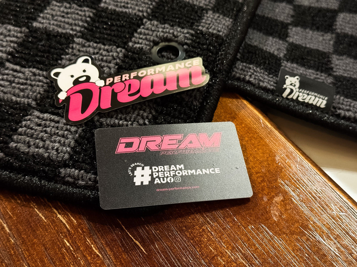 Dream Performance badge and card resting on grey and black checker carpet