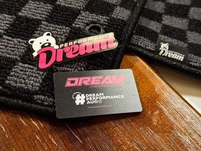 Dream Performance badge and card resting on grey and black checker carpet