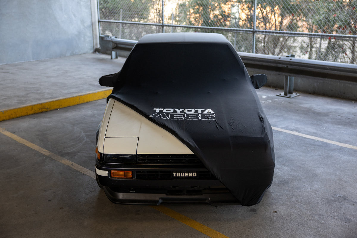 Toyota AE86 Hachi Roku indoor car cover pulled back to show a Sprinter Trueno front end